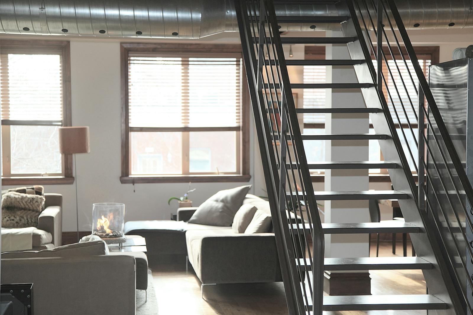 Bright and modern loft interior featuring cozy furniture and industrial elements, perfect for urban living.